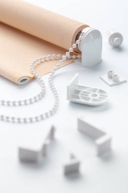 beyaz yüzeyüzerinde plastik parçaları ile haddelenmiş bej kepenk