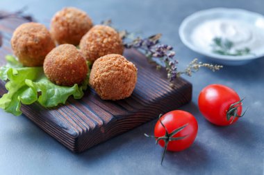 Sebze ile masa üzerinde ahşap tahta üzerinde kızarmış falafel topları