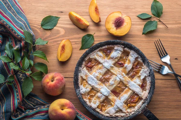 Fresh homemade peach pie on table with fresh fruit