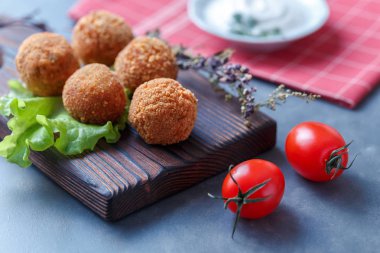 Sebze ile masa üzerinde ahşap tahta üzerinde kızarmış falafel topları
