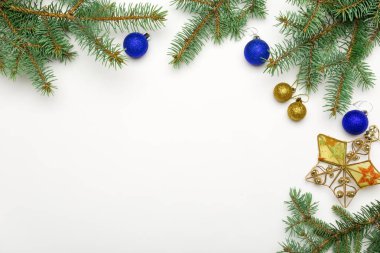 Topları ve beyaz arka plan üzerinde yıldız baubles ile tatil çerçeve Noel dekoratif çam dalları