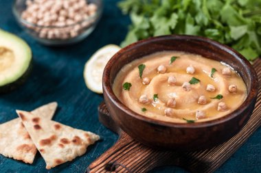 Masa üzerinde ahşap tahta üzerinde kase geleneksel humus çanak