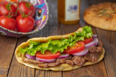 Kavrulmuş et, domates, soğan ve marul mutfak masasında lezzetli taze ev yapımı pita sandviç. 