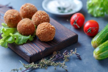Sebze ile masa üzerinde ahşap tahta üzerinde kızarmış falafel topları