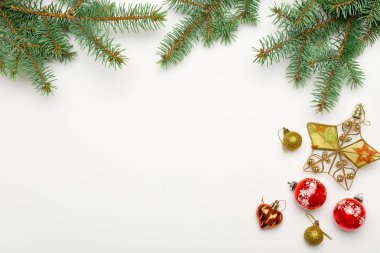 Topları ve beyaz arka plan üzerinde yıldız baubles ile tatil çerçeve Noel dekoratif çam dalları