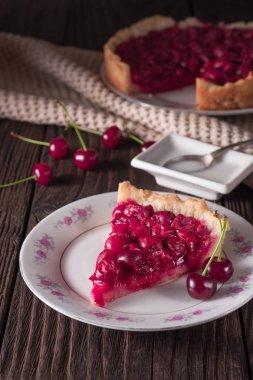 Rustik masada tabakta pişmiş taze vişneli börek dilimi