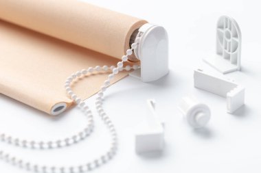 beyaz yüzeyüzerinde plastik parçaları ile haddelenmiş bej kepenk