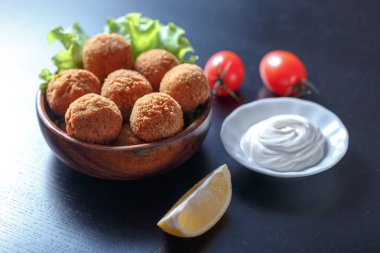 Domates ve sos ile masada kase kızarmış falafel topları