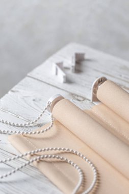 beyaz ahşap masa üzerinde haddelenmiş bej kepenkler