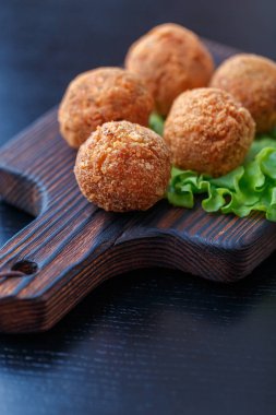 Masa üzerinde ahşap tahta üzerinde kızarmış falafel topları