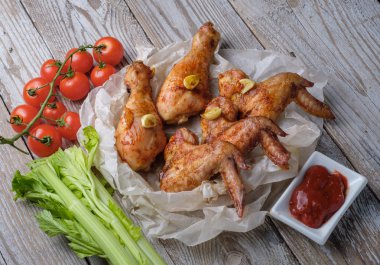 Sos ve sebze ile masada kavrulmuş tavuk kanatları