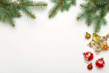 Topları ve beyaz arka plan üzerinde yıldız baubles ile tatil çerçeve Noel dekoratif çam dalları
