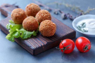 Sebze ile masa üzerinde ahşap tahta üzerinde kızarmış falafel topları