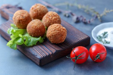Sebze ile masa üzerinde ahşap tahta üzerinde kızarmış falafel topları