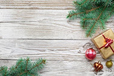 Dekoratif çam dalları ile kutusu ve süs eşyaları üzerinde ahşap arka plan mevcut Noel tatil çerçeve