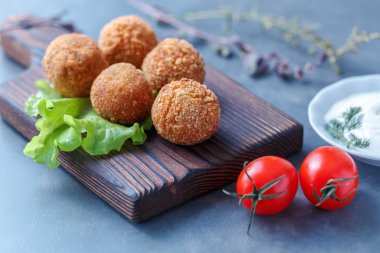 Sebze ile masa üzerinde ahşap tahta üzerinde kızarmış falafel topları
