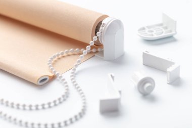 beyaz yüzeyüzerinde plastik parçaları ile haddelenmiş bej kepenk