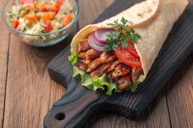 Rustik masa üzerinde ızgara et ve salata kase ile ev yapımı shawarma