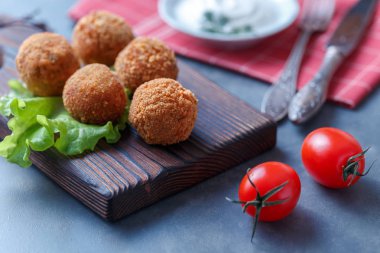 Sebze ile masa üzerinde ahşap tahta üzerinde kızarmış falafel topları