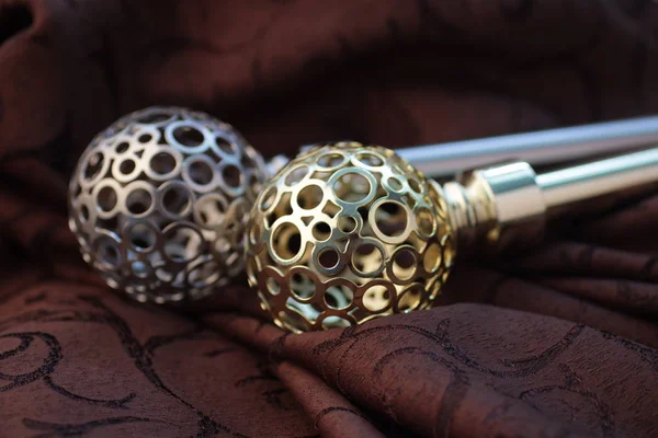 Close-up of curtain poles with ornate spheres endings and curtain