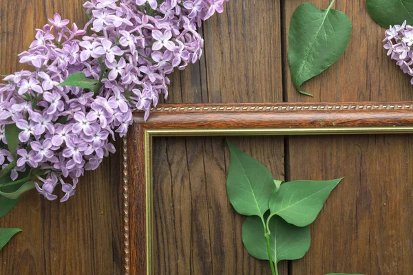 Ahşap arka plan üzerinde leylak çiçekleri ile Vintage çerçeve, bahar konsepti