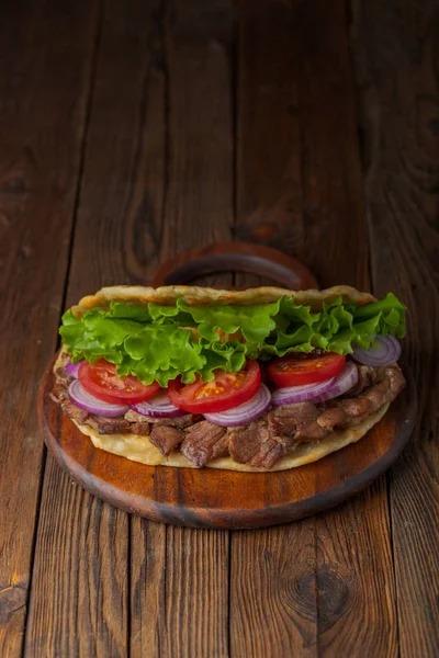 おいしい新鮮な自家製ジャイロ サンドイッチ ロースト肉 トマト 玉ねぎ レタスの素朴なテーブルの上に木の板 — ストック写真