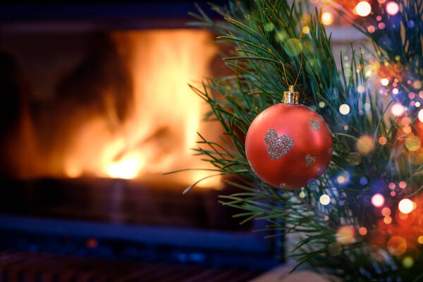 Рождественский орнамент на елке на фоне камина
