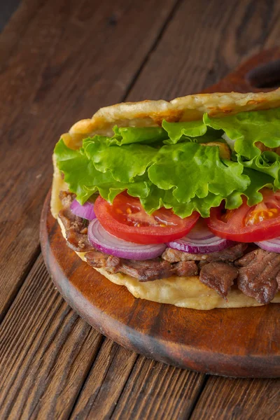 美味新鲜的自制陀螺仪三明治与烤肉 西红柿 洋葱和生菜在木板上的乡村餐桌 — 图库照片