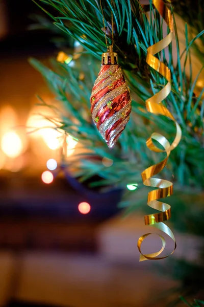 벽난로 배경에 크리스마스 전나무 나무에 매달려 화려한 Bauble — 스톡 사진