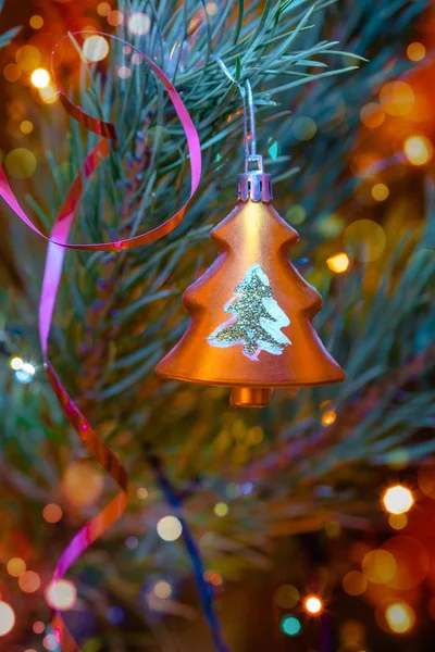 Gold tree shaped Christmas ornament on festive fir tree background