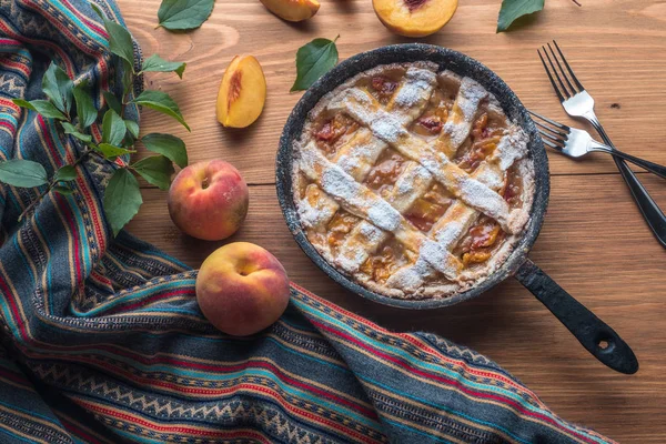 Fresh homemade peach pie on table with fresh fruit