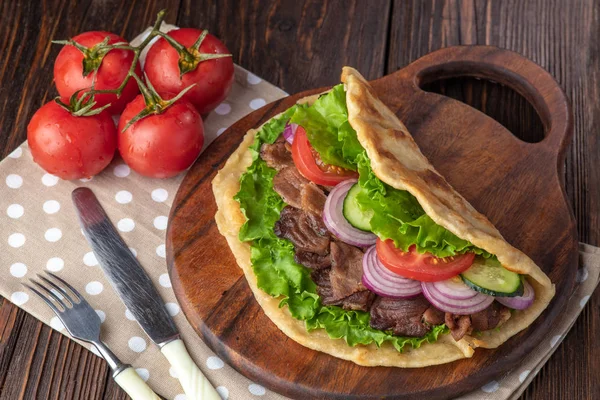 Sığır eti ve sebze lekeli havlu ile ahşap tahta üzerinde taze tortilla sandviçle