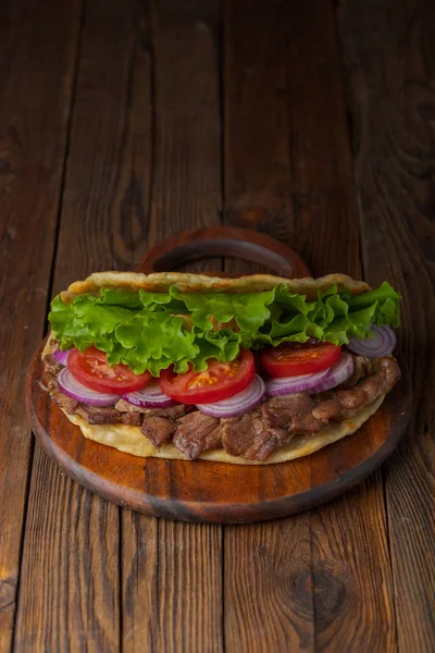 美味新鲜的自制陀螺仪三明治与烤肉 西红柿 洋葱和生菜在木板上的乡村餐桌 — 图库照片
