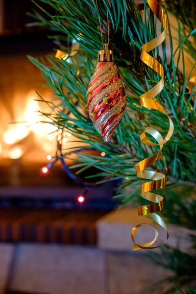 벽난로 배경에 크리스마스 전나무 나무에 매달려 화려한 Bauble — 스톡 사진
