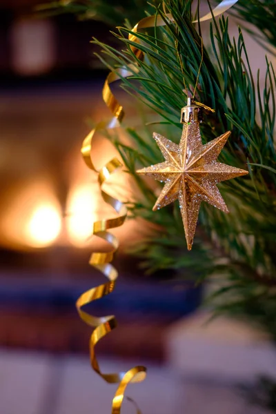 벽난로 배경에 크리스마스 전나무 나무에 매달려 모양의 Bauble — 스톡 사진
