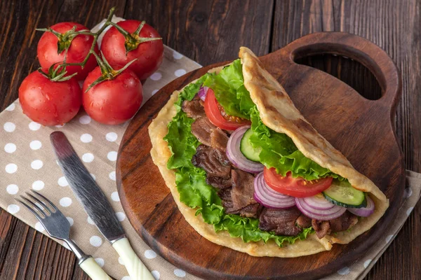 Sığır eti ve sebze lekeli havlu ile ahşap tahta üzerinde taze tortilla sandviçle