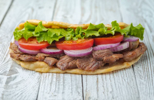 新鲜的自制玉米饼三明治与烤肉 西红柿 洋葱和生菜在木桌上 — 图库照片