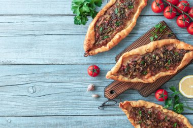 turkuaz ahşap masa üzerinde Tasty Türk pide üst görünümü