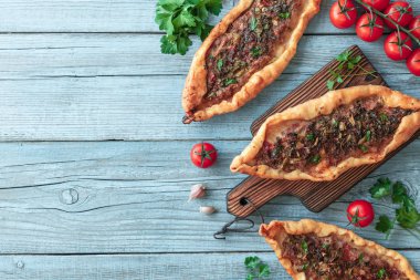 turkuaz ahşap masa üzerinde Tasty Türk pide üst görünümü