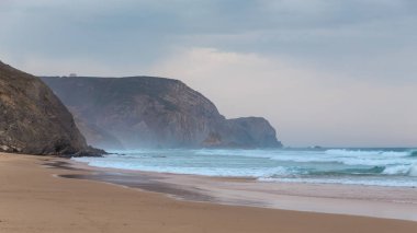 Praia da Mareta fırtınalı havalarda doğal kumlu plajda Dalgalar, Portekiz