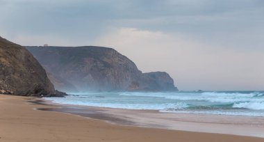 Praia da Mareta fırtınalı havalarda doğal kumlu plajda Dalgalar, Portekiz