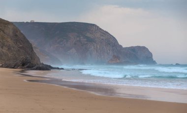 Praia da Mareta fırtınalı havalarda doğal kumlu plajda Dalgalar, Portekiz