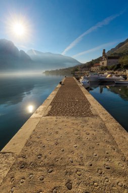 Perast tatil beldesinde gün batımında taş iskele ile kıyı manzarası, Kotor Körfezi, Karadağ, Avrupa