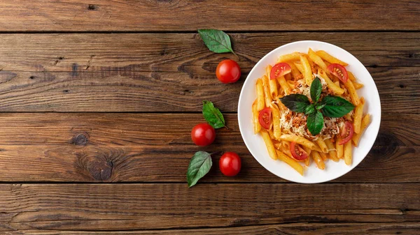 木桌上的新鲜博洛尼亚意大利面 桌上有西红柿和罗勒叶 — 图库照片