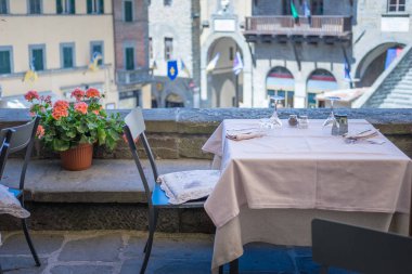Cortona, Arezzo, Toskana, İtalya'da lüks restoran masaları servis edilen sokak sahnesi.
