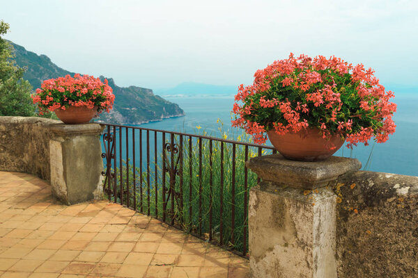 Potted flowers with seascape behind railings in Ravello, Amalfi Coast, Italy