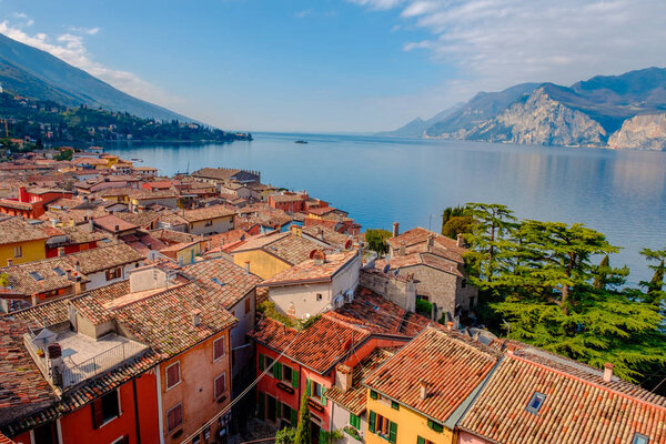 Scenery of Malcesine cityscape with traditional houses and tiled roofs and lake Garda, Riva del Garda, Italy, Europe