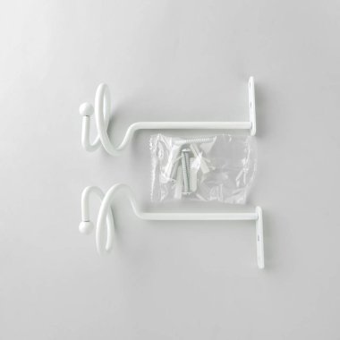 Gri arka plan üzerinde bağlantı elemanları ile perde için metal bükümlü bekleme.