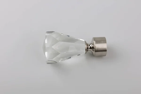 Simple crystal plug for curtain eaves on grey background