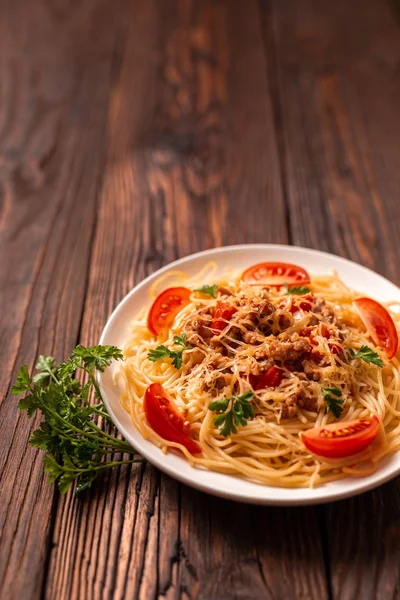 Pasta boloñesa con salsa de tomate y carne picada, queso parmesano rallado y perejil fresco - pasta italiana sana casera sobre fondo rústico de madera . —  Fotos de Stock